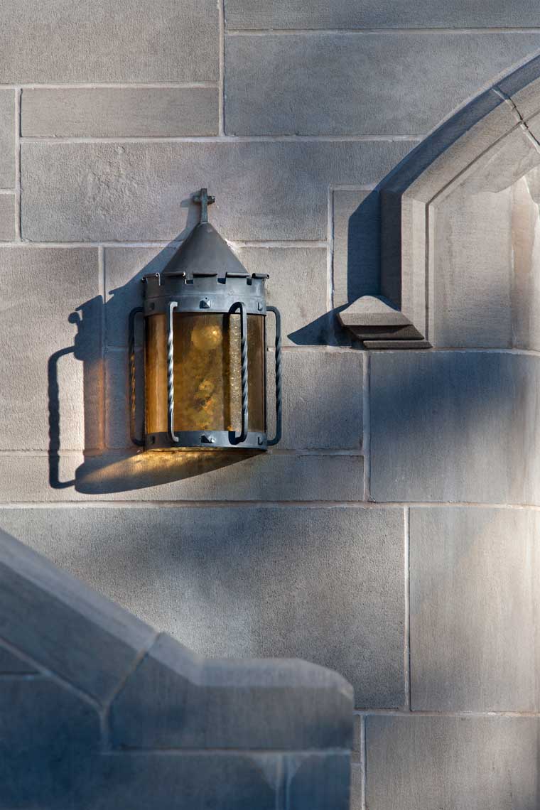 A detail of an exterior sconce and the surrounding stonework detail