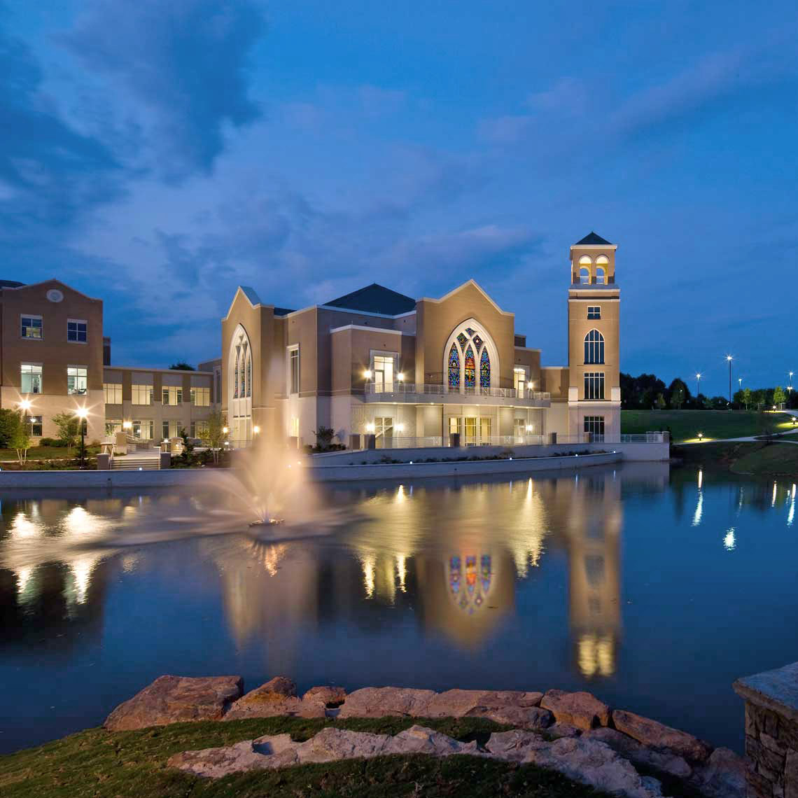 A twilight exterior view across the water of the Cecil B. Day Chapel at Perimeter Church