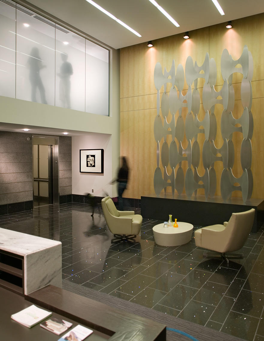 An interior lobby view of Plaza Midtown Apartments, with art and people on two floors