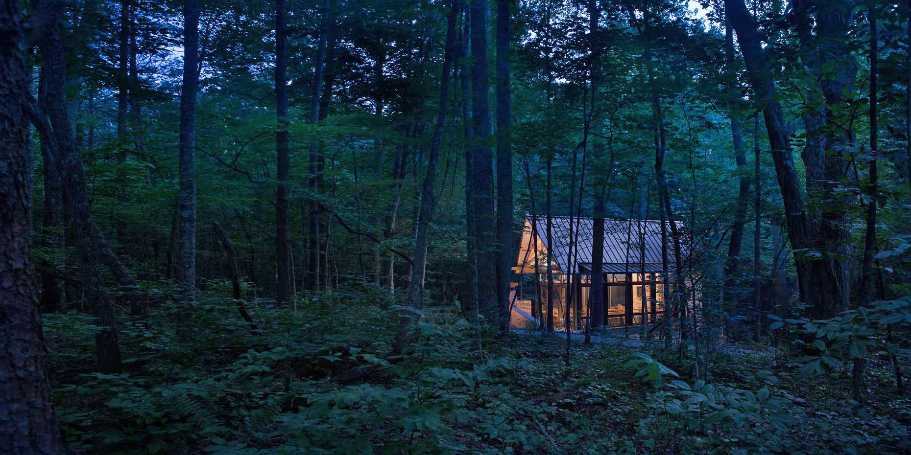 A view of the St. Francis Springs Outdoor Chapel situated in the woods at twilight
