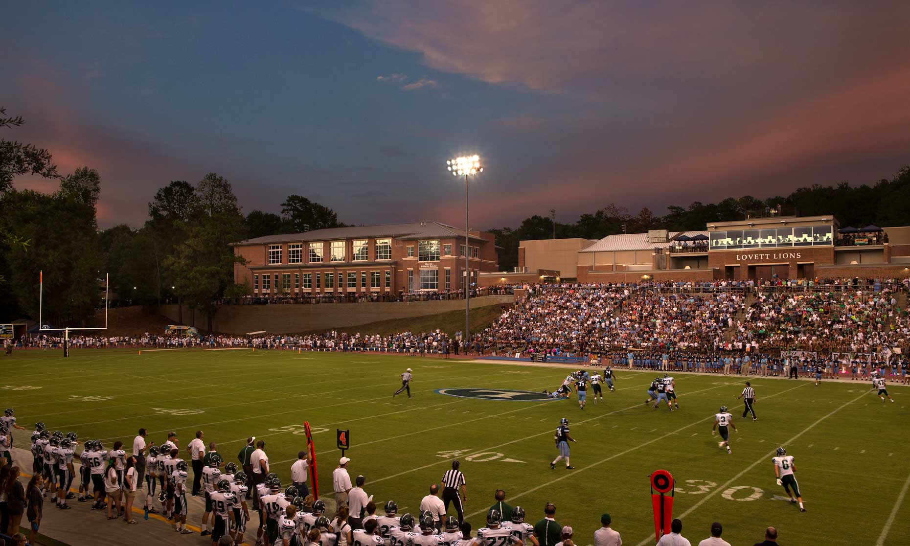 An exterior twilight view of a football game at the Lovett School Football Venue