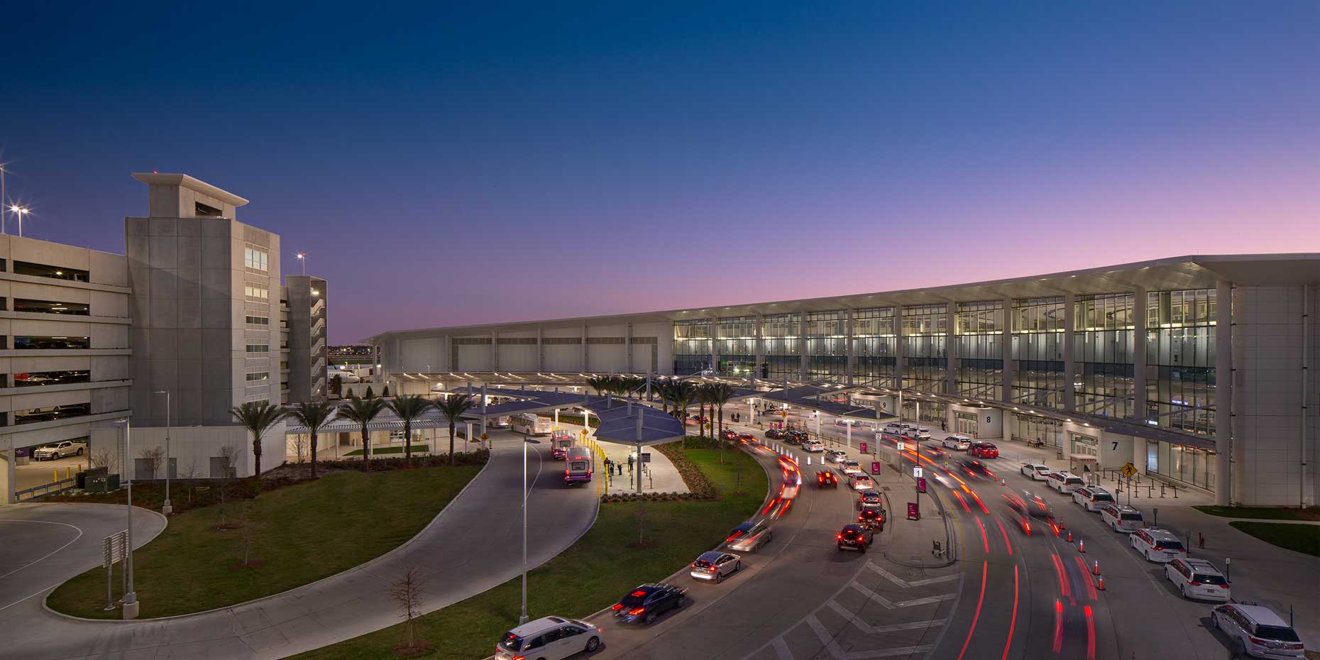 Exterior twilight view of arrivals and parking at the MSY North Terminal