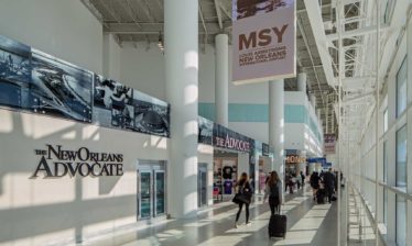 Interior daytime view of a walkway with travelers at the MSY North Terminal - Atlanta Architectural Photographers