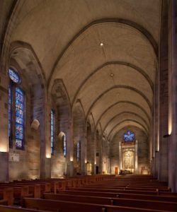 A soaring view of the sanctuary of the Cathedral of Christ the King, with illuminated stained glass