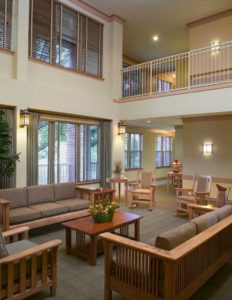 A photograph of the inviting two-story Gathering Room at Columbia Heritage Senior Residences