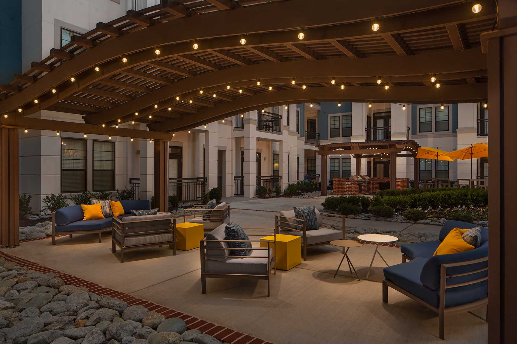 A photo of the grill courtyard at Elle of Buckhead in Atlanta, Georgia, featuring curved wood arbors