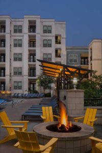 A photo of the pool deck with welcoming firepit in the foreground at Elle of Buckhead in Atlanta, Georgia