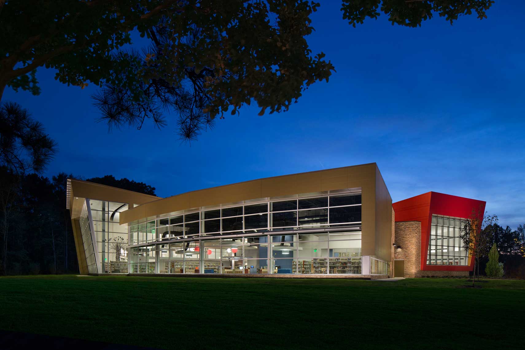 A twilight view of the Wolf Creek Library showing both interior and exterior architectural details