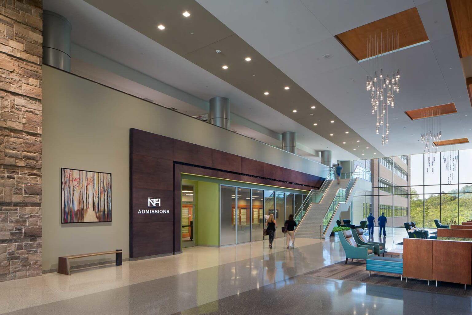 A view of the expansive Admissions lobby, with comfortable seating and the grand stair
