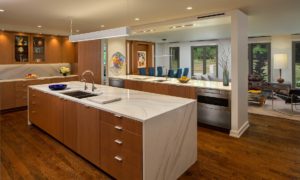 A view of a kitchen and dining area in a custom residence, emphasizing warm wood
