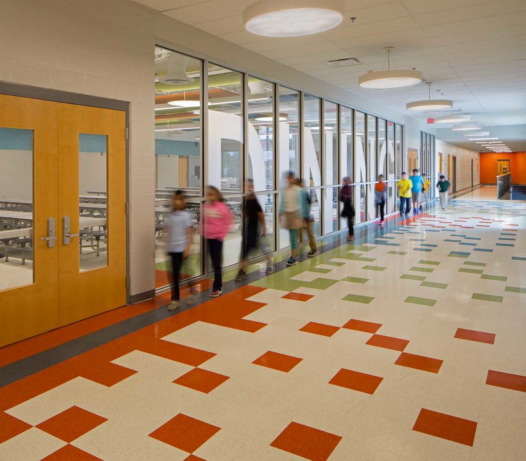 A view of Tusculum Elementary Corridor with students walk past window graphics