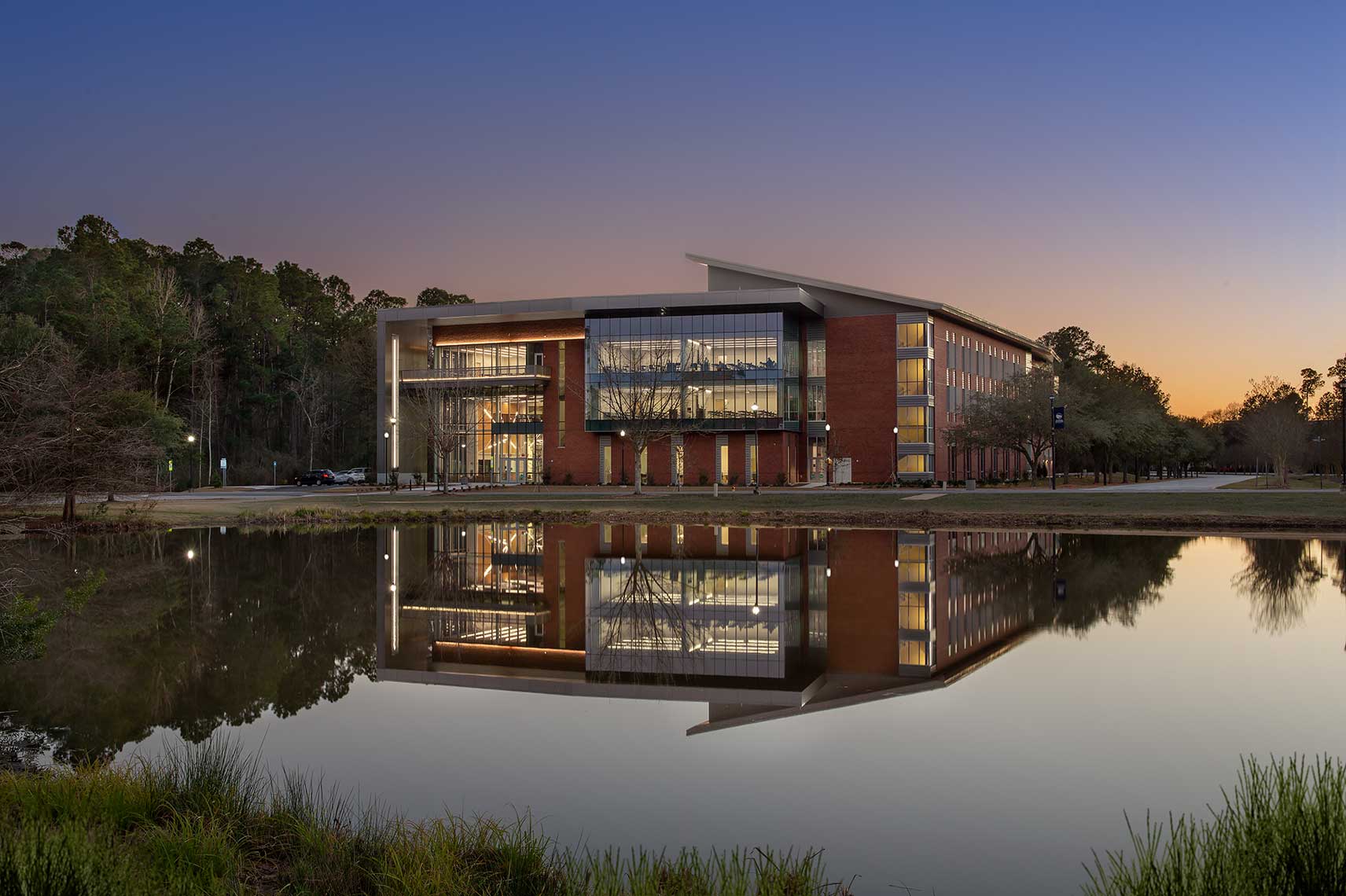 A twilight view of the Engineering Building and a mirror-like reflection across a pond