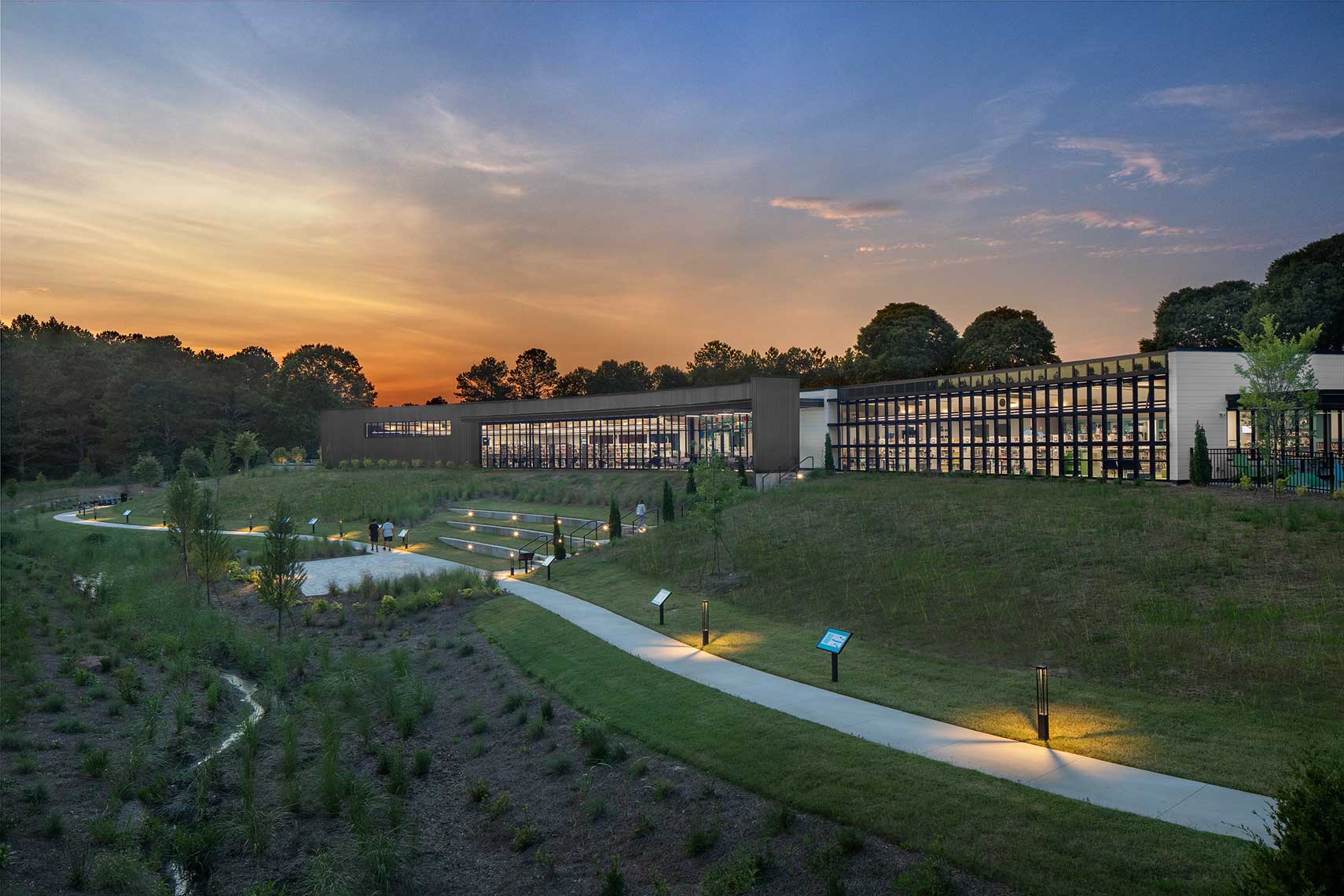 A twilight view of the south facade of the Denmark Branch Library designed by McMillan Pazdan Smith Architecture