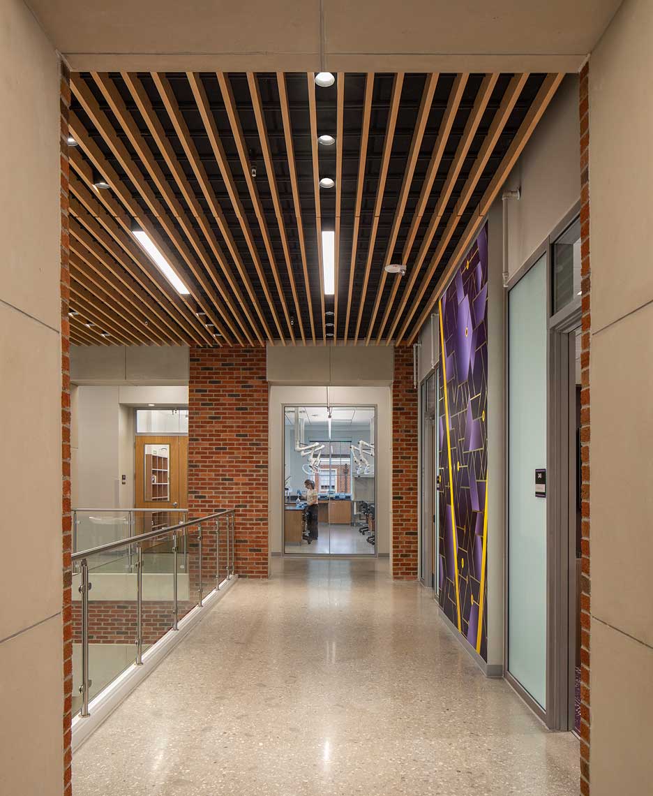 A view of the elevator lobby within the Tennessee Tech Ashraf Islam Engineering Building with a view into a lab, showing a student working
