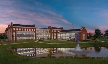 A twilight view of the Tennessee Tech Ashraf Islam Engineering Building from across the water, highlighting the transparency of the glass exposure to the interior.