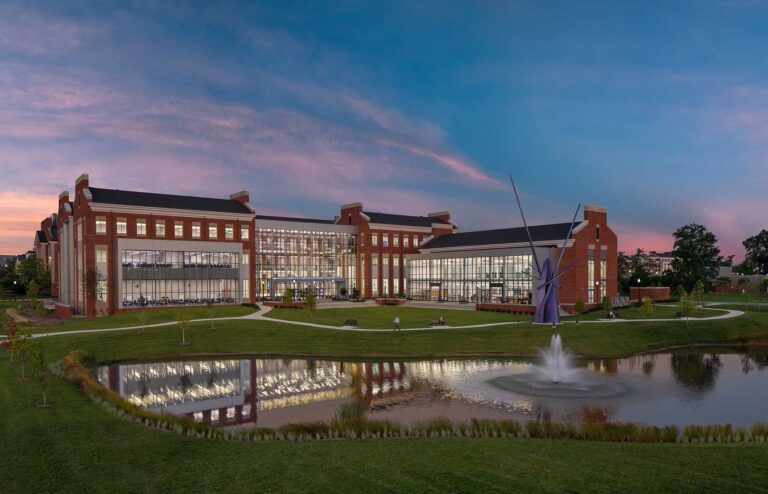 A twilight view of the Tennessee Tech Ashraf Islam Engineering Building from across the water, highlighting the transparency of the glass exposure to the interior.