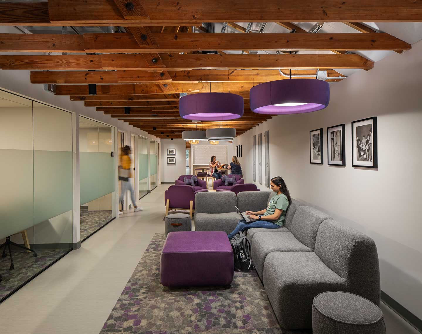 A view of the upper level space of Hopkins Hall at Agnes Scott College showing private group study rooms, and comfortable collaboration spaces with students in them