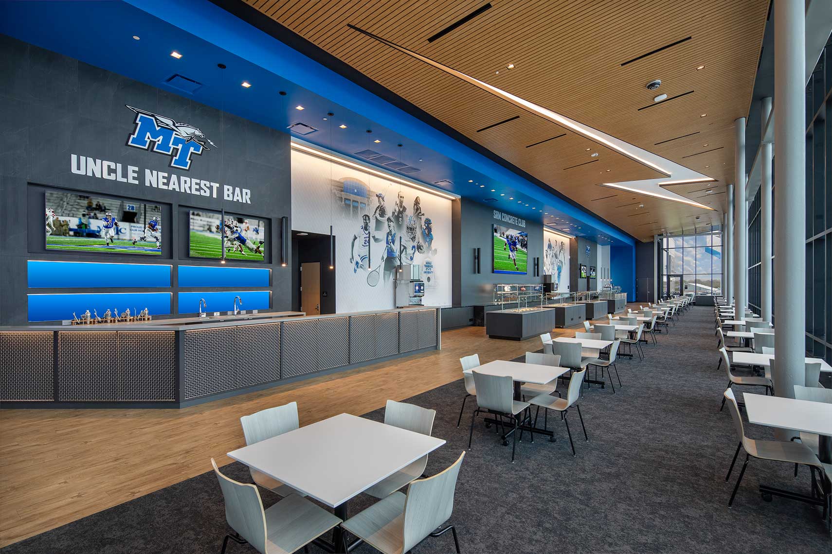 An interior of the seating and bar in the Club Lounge of the MTSU Student-Athlete Performance Center, highlighting the inset lightning bolt light fixture in the ceiling