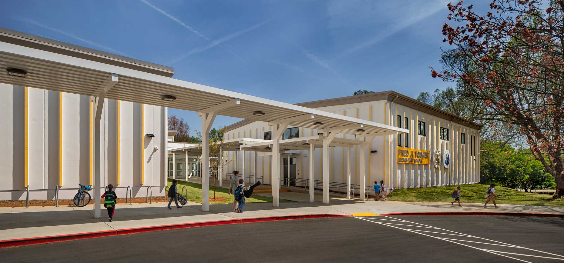 A front exterior photo of students and parents at the drop-off area at Toomer Elementary School in Atlanta, Georgia