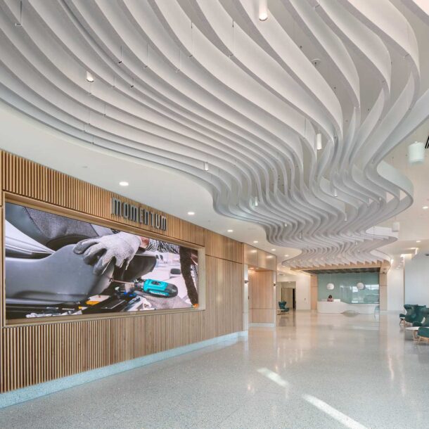 A photograph of the Quick Start - Hyundai Mobility Training Center of Georgia from the entry, emphasizing curved ceiling baffles