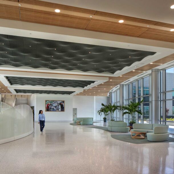 An interior lobby space with people walking inside and outside of the Quick Start - Hyundai Mobility Training Center of Georgia by SSOE Group
