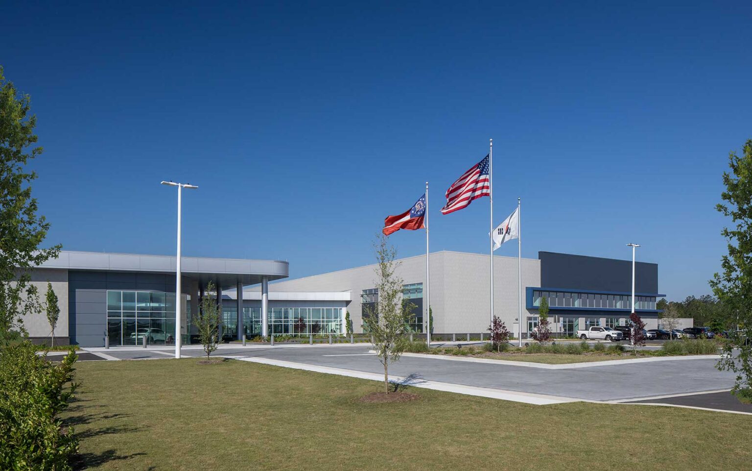 A daytime exterior view of the front facade and courtyard of the Quick Start - Hyundai Mobility Training Center of Georgia by SSOE Group