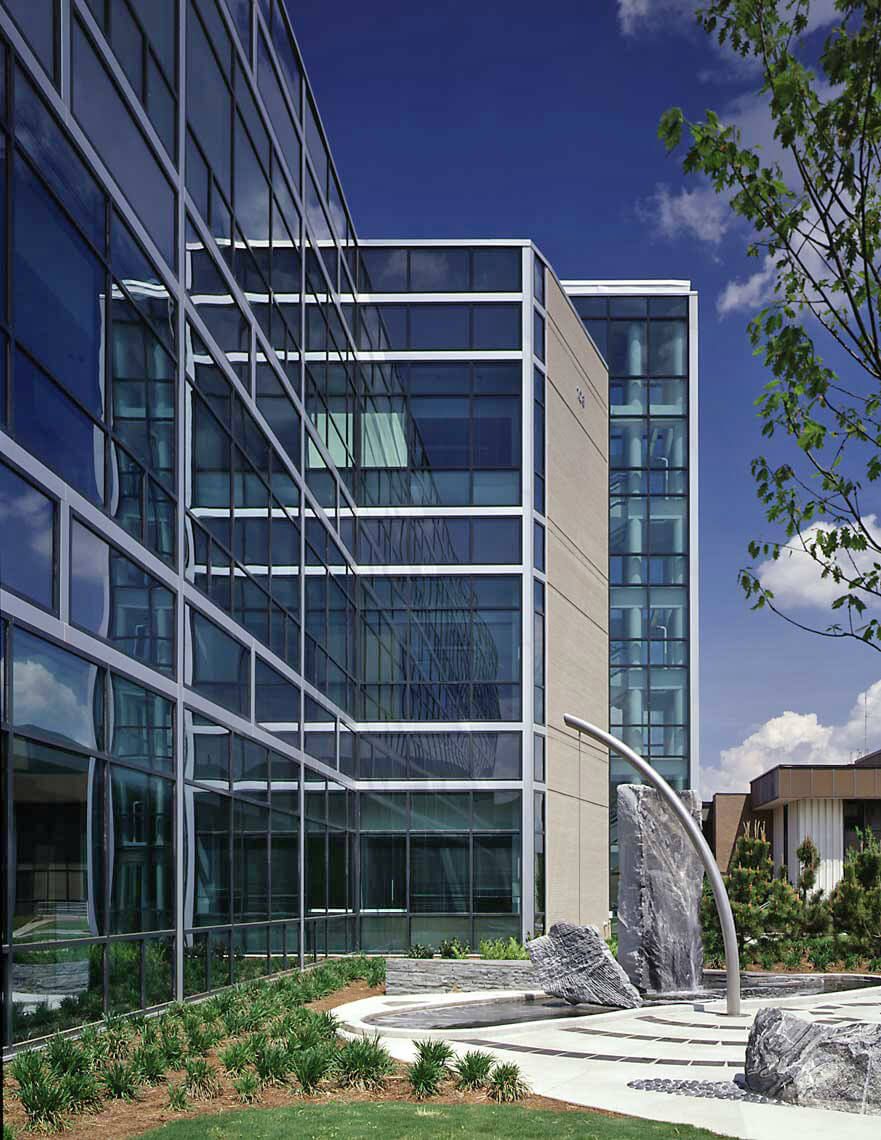 A view with glass reflectivity, stone, water, and metal at the entrance to the CDC facility in Chamblee