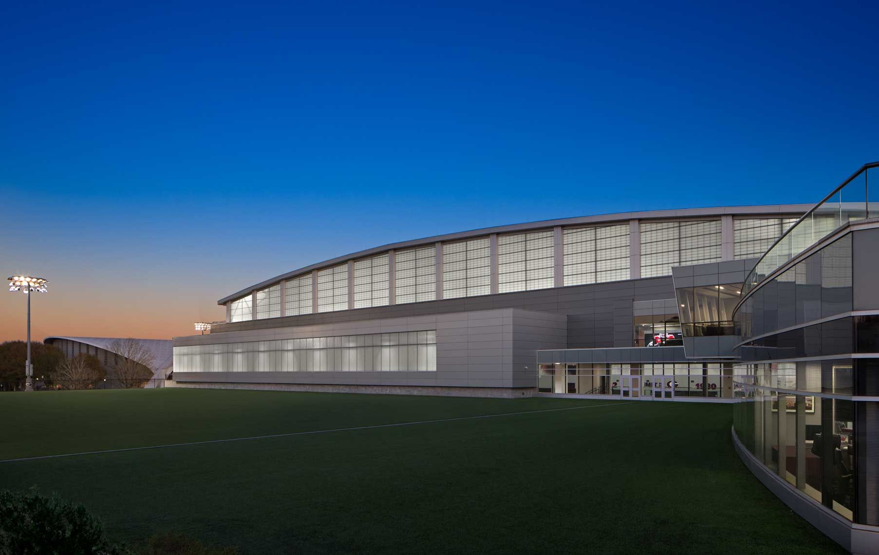 An exterior twilight view of a close-up of the University of Georgia Indoor Athletic Facility