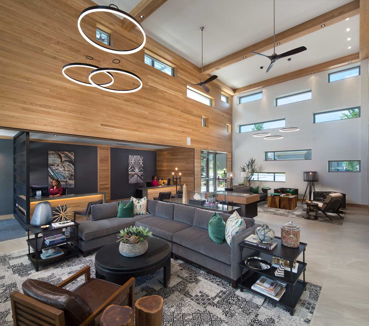 An interior daytime view of the Gables Brookhaven Leasing office, showing bold use of wood and windows
