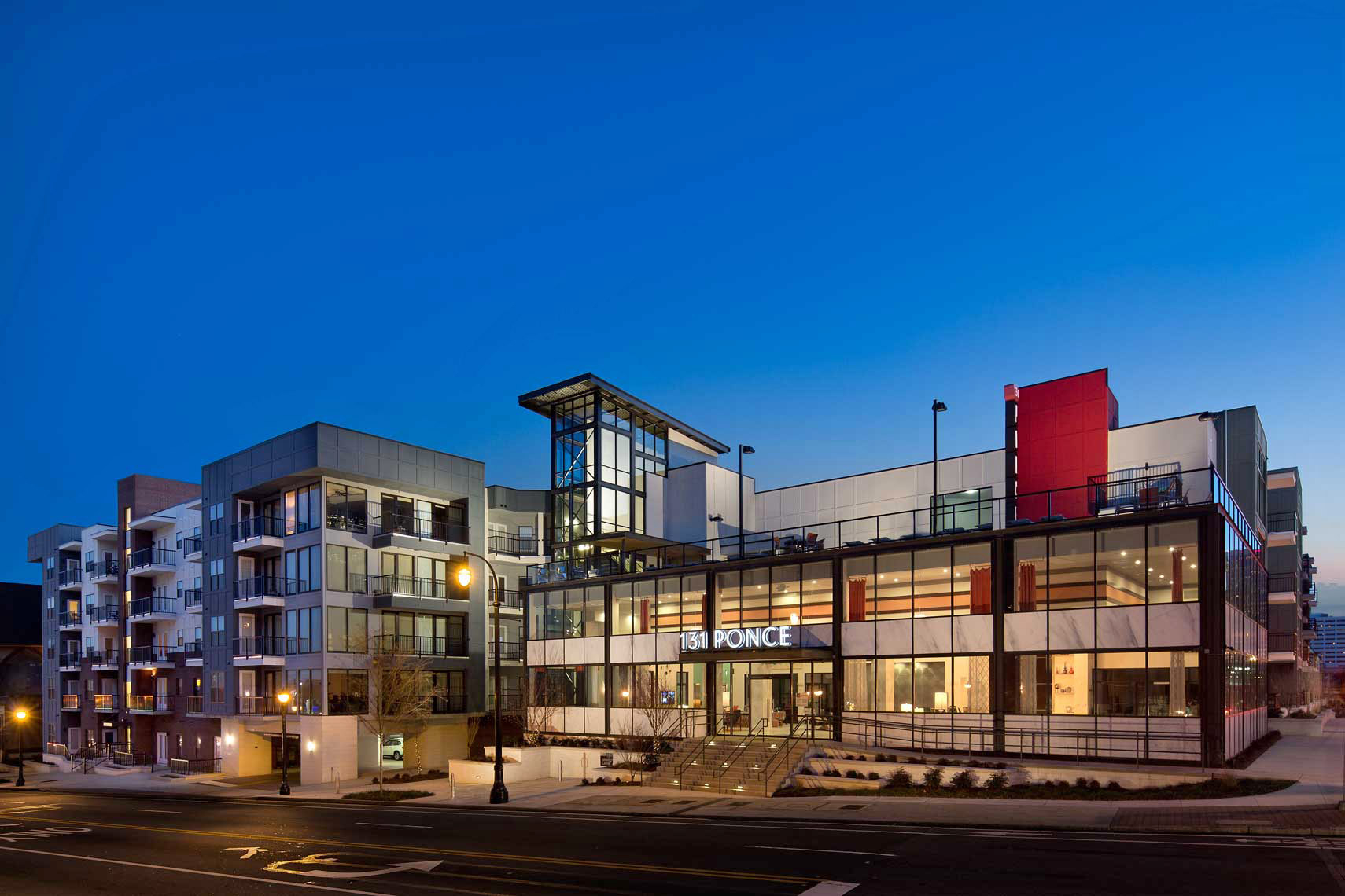 A twilight view of the main buildings at 131 Ponce Midtown, showing the bold design and view to the inside